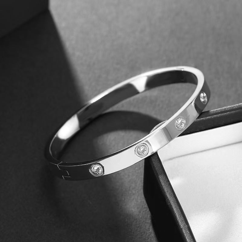 Silver bracelet with embedded stones on a dark surface