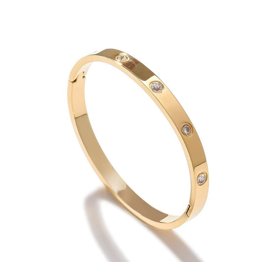 Gold bracelet with small diamonds on a white background