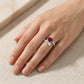Real-life hand view of a model displaying an alternative bridal ruby and princess-cut crystal Toi et Moi ring under soft light.