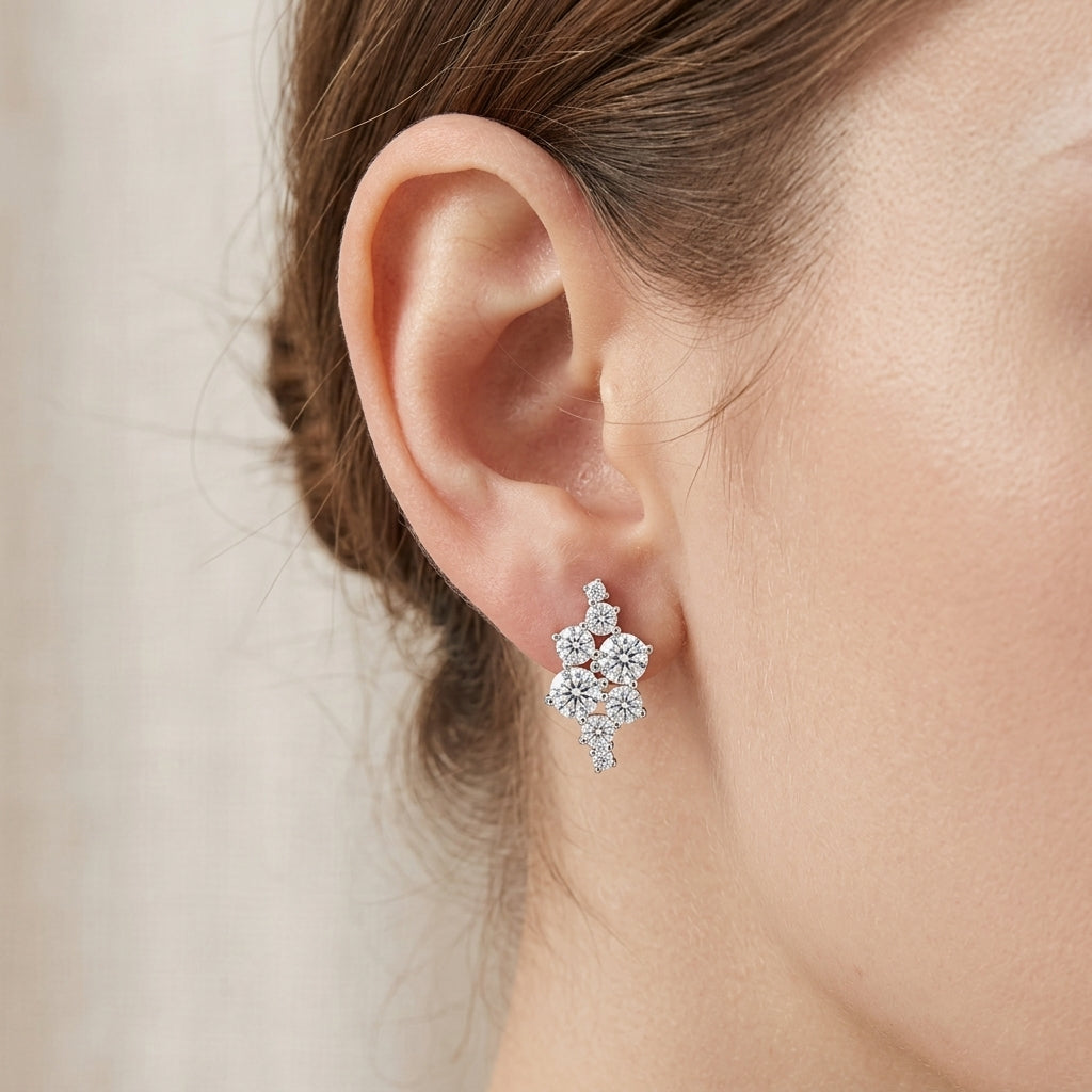 Model wearing asymmetric cluster moissanite stud earrings showing earlobe fit.