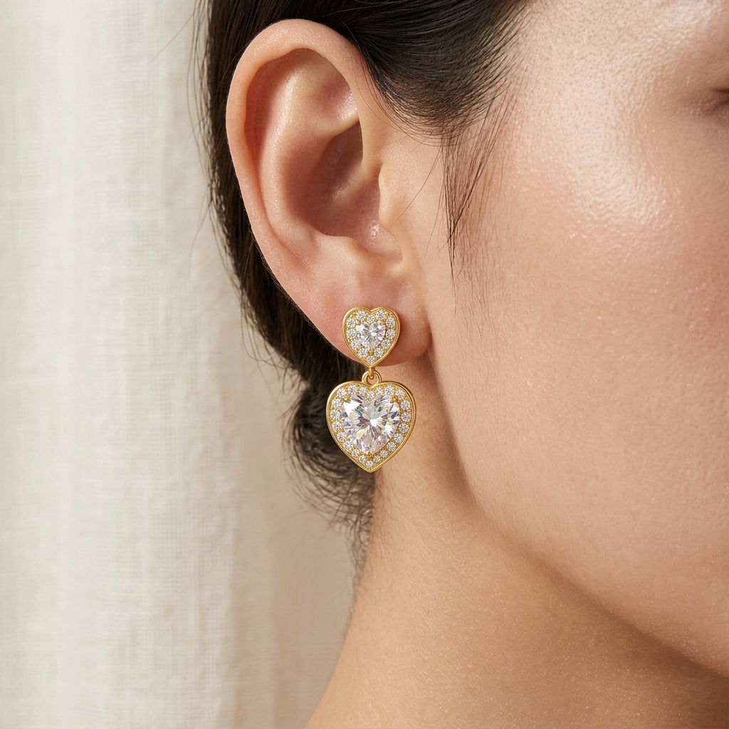 Close-up view of model showing gold heart halo moissanite drop earring on ear.
