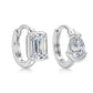 Front view of asymmetrical pear cut and emerald cut diamond bezel huggie earrings.