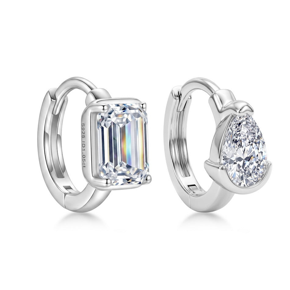Front view of asymmetrical pear cut and emerald cut diamond bezel huggie earrings.