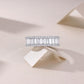 Baguette moissanite double halo eternity band resting on neutral background.