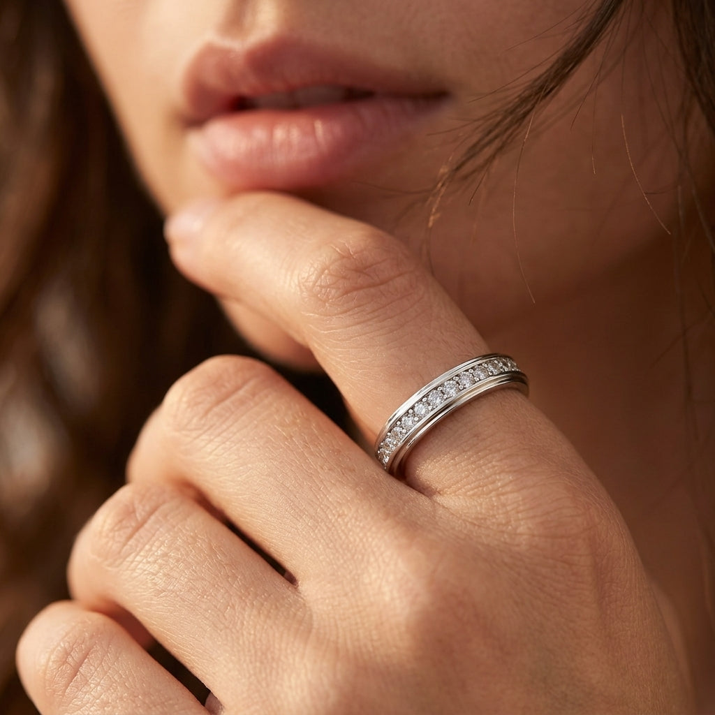 Model wearing beveled edge channel set moissanite eternity ring on hand.