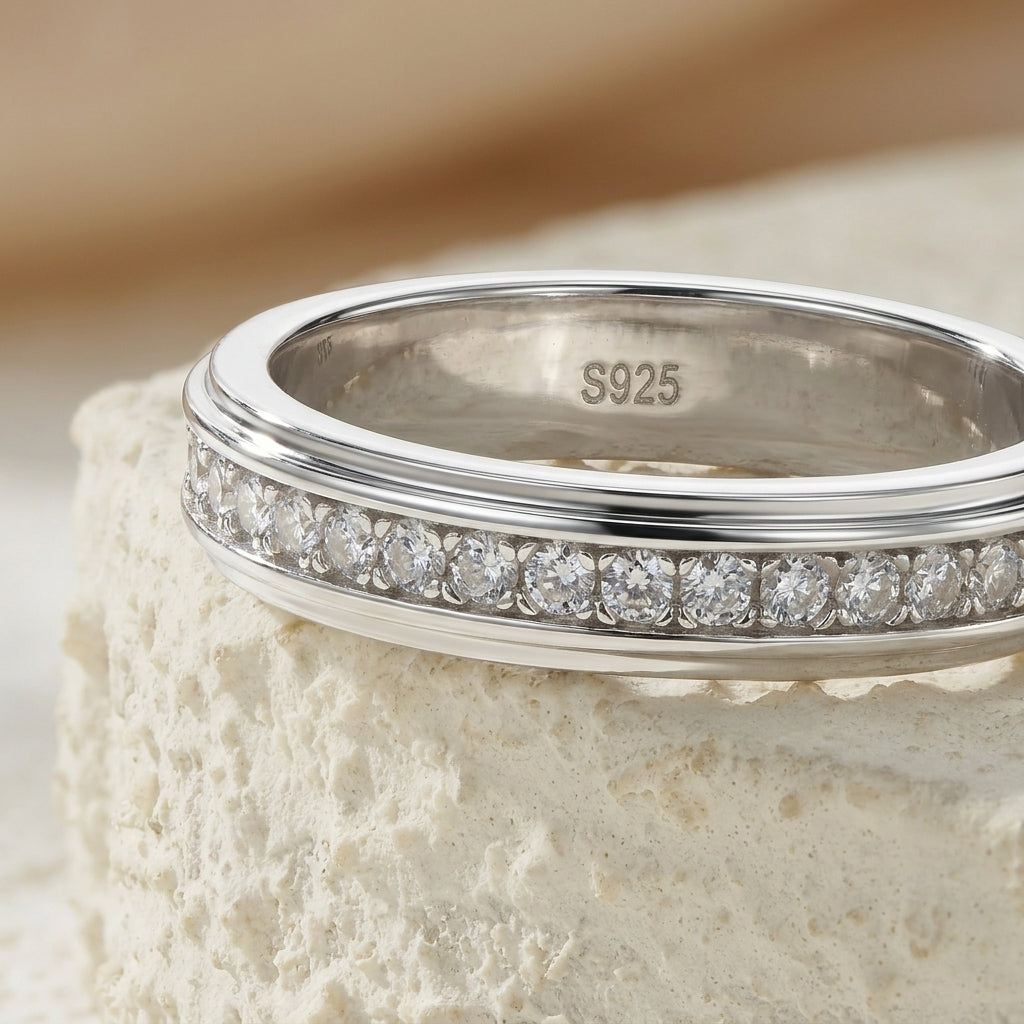 Macro view showing channel setting and S925 stamp on beveled moissanite eternity band.