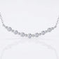 Close-up view of bezel set graduated moissanite and polished bead spacers on smile bar.