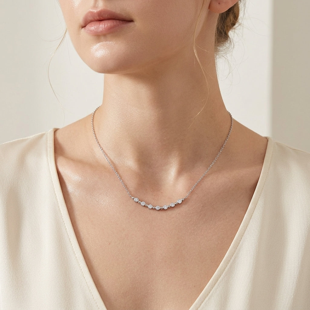 Model wearing bezel set moissanite station smile bar necklace on collarbone.