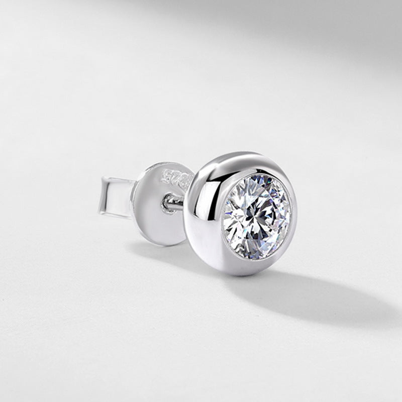 Close-up view of smooth bezel setting and ear nut on round diamond stud earring.
