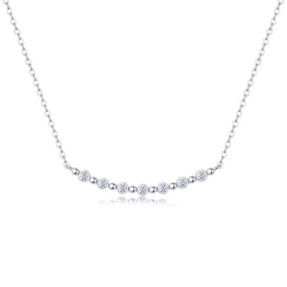 Bezel set moissanite station smile bar necklace in sterling silver with bead spacers.