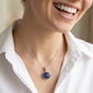 Woman wearing a silver necklace with a blue pendant