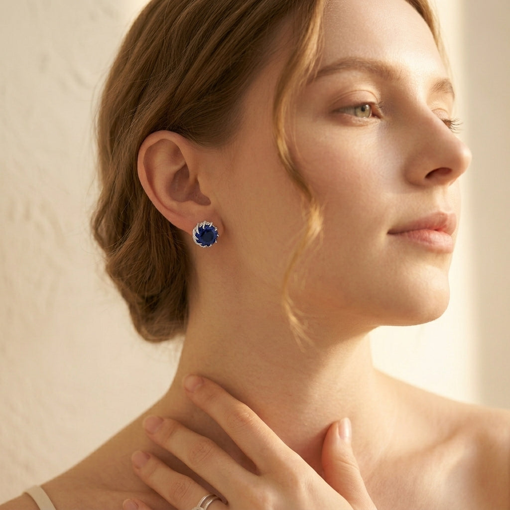 Close-up of a woman wearing blue gemstone earrings with a soft background
