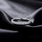 Brilliant full eternity lab grown diamond band ring lying flat on dark black silk fabric