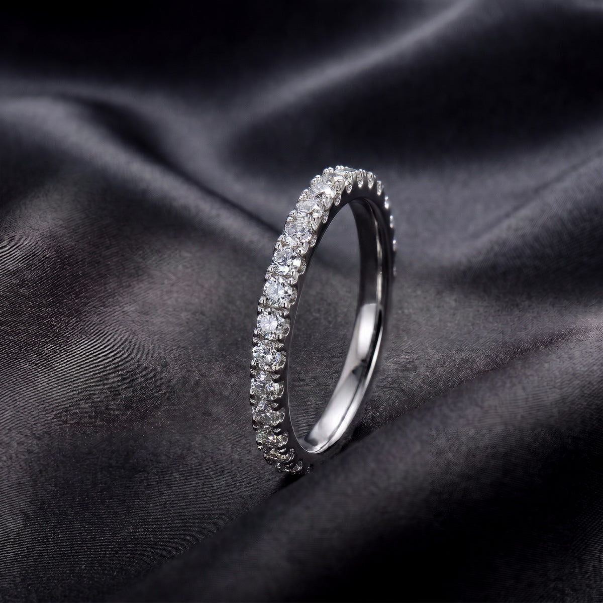 Side profile view of brilliant full eternity lab grown diamond ring on black silk