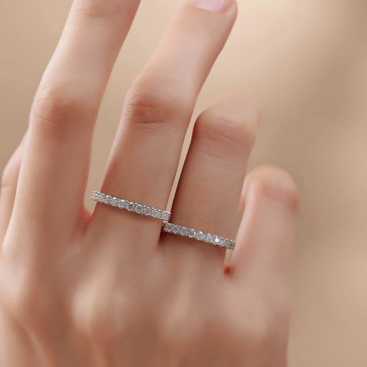Woman wearing two brilliant full eternity lab grown diamond stacking rings on fingers