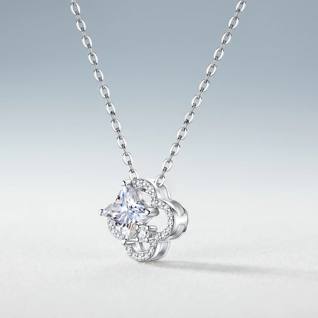Perspective view of celestial star cut moissanite openwork clover pendant necklace on slate background.