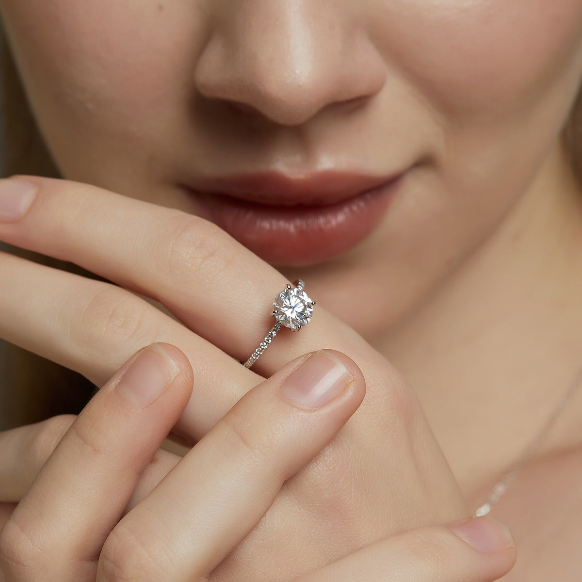 Model wearing classic 4-prong round cut lab grown diamond solitaire engagement ring on finger