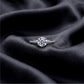 Front view of round brilliant lab grown diamond engagement ring with accent stones on dark black silk