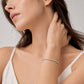 Model wearing classic 4-prong round lab-grown diamond eternity tennis bracelet.