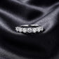 Front view of classic 7 stone round lab grown diamond wedding band on dark black silk fabric