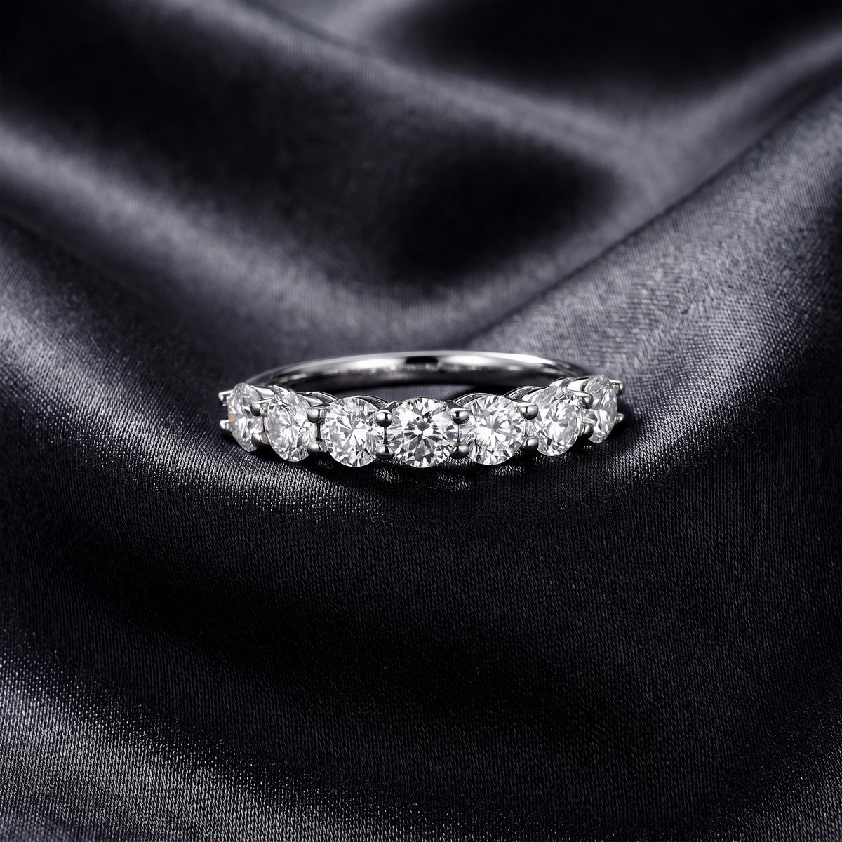 Front view of classic 7 stone round lab grown diamond wedding band on dark black silk fabric