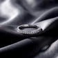 Classic channel set lab grown diamond wedding band resting flat on dark black silk fabric