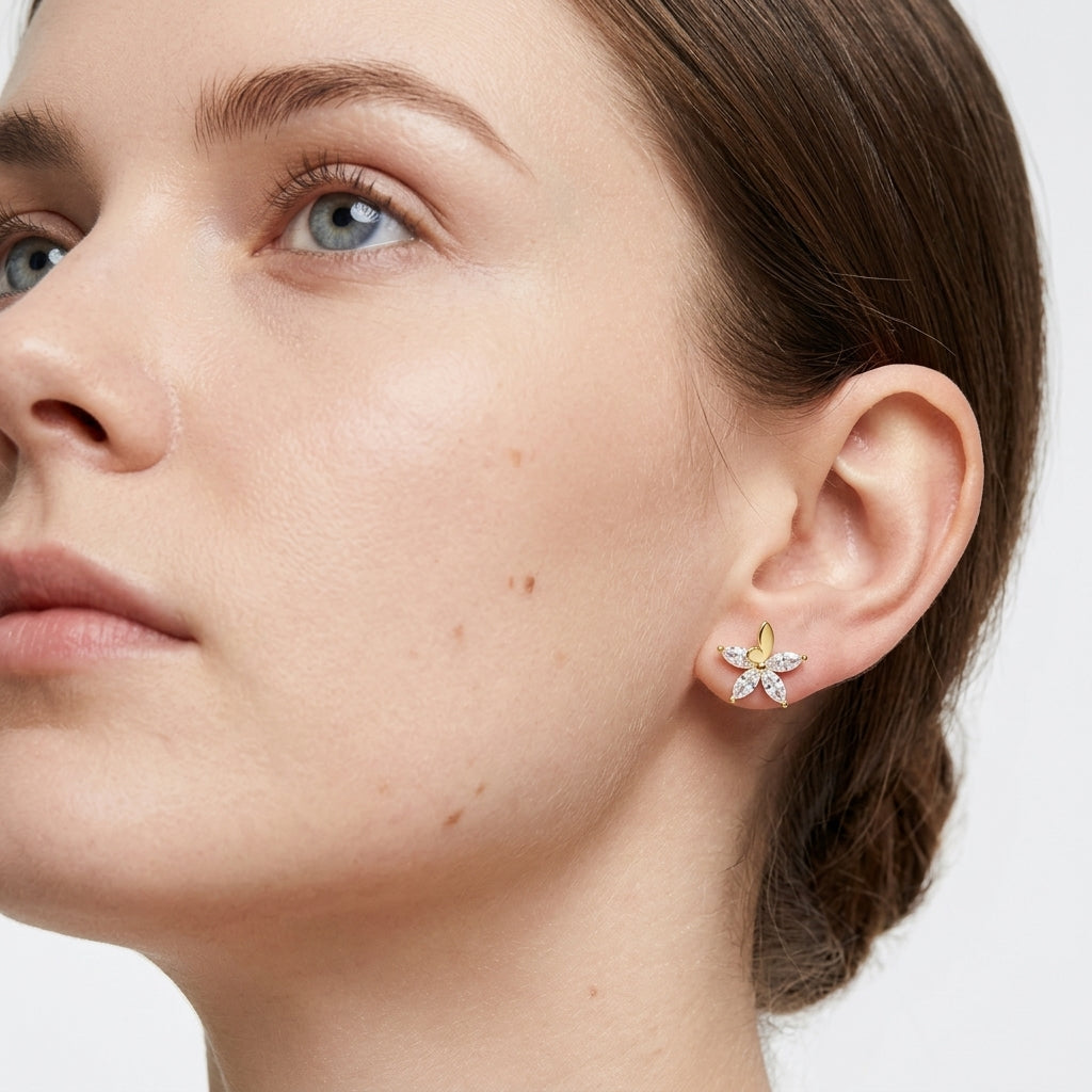High-end fashion lookbook view of a model wearing classic gold butterfly flower marquise moissanite stud earrings.