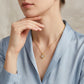 Classic gold pear moissanite open heart necklace worn by model with blue shirt, elegant style