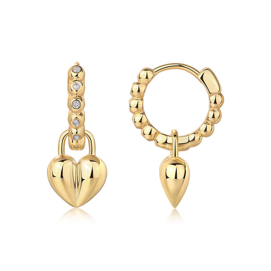 Classic gold beaded huggie hoop earrings with moissanite accents and dangling puffed heart lock charm on white background.