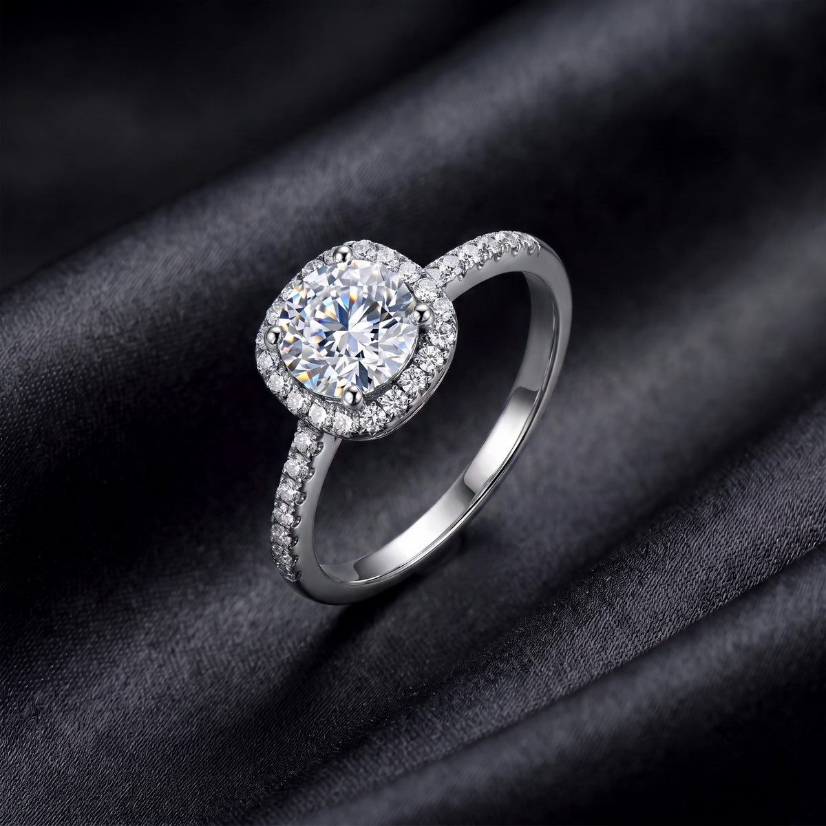 Side angle view of round cut cushion halo lab grown diamond engagement ring with pavé band on black silk