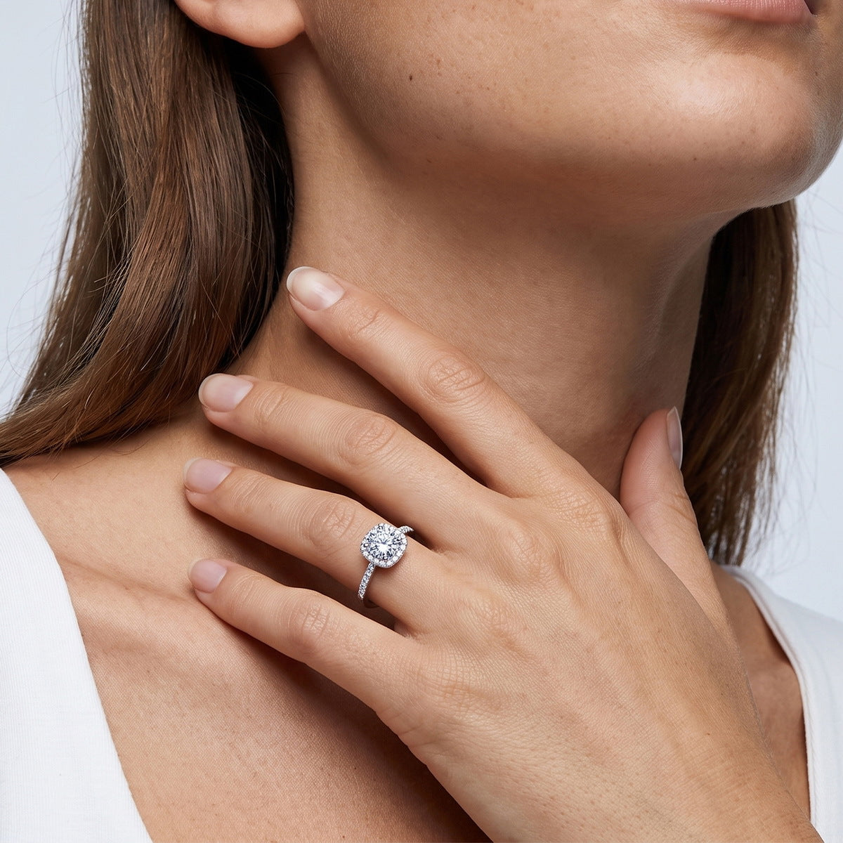 Woman wearing classic round cut cushion halo lab grown diamond engagement ring on finger