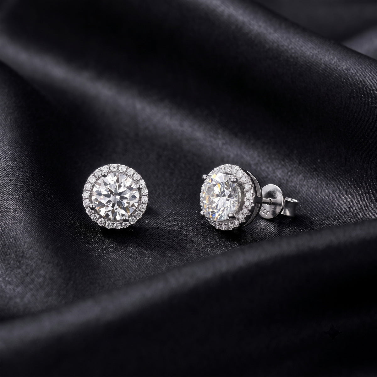 Close up showing front and side post profile of round halo lab grown diamond stud earrings on black silk