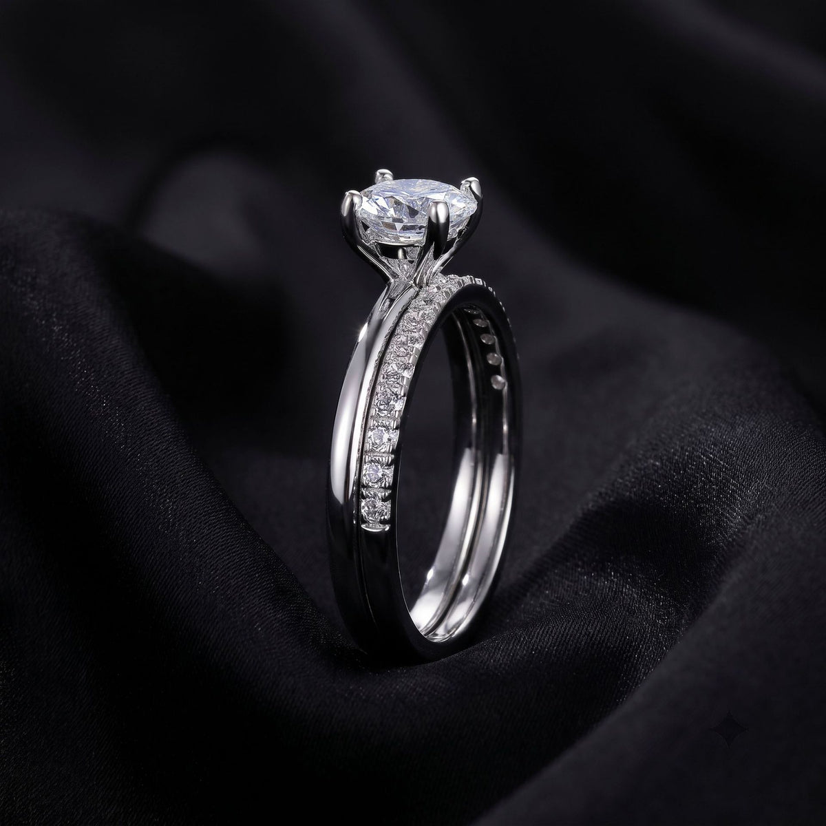 Side profile view showing 4-prong setting of round lab grown diamond stacking ring set on dark silk