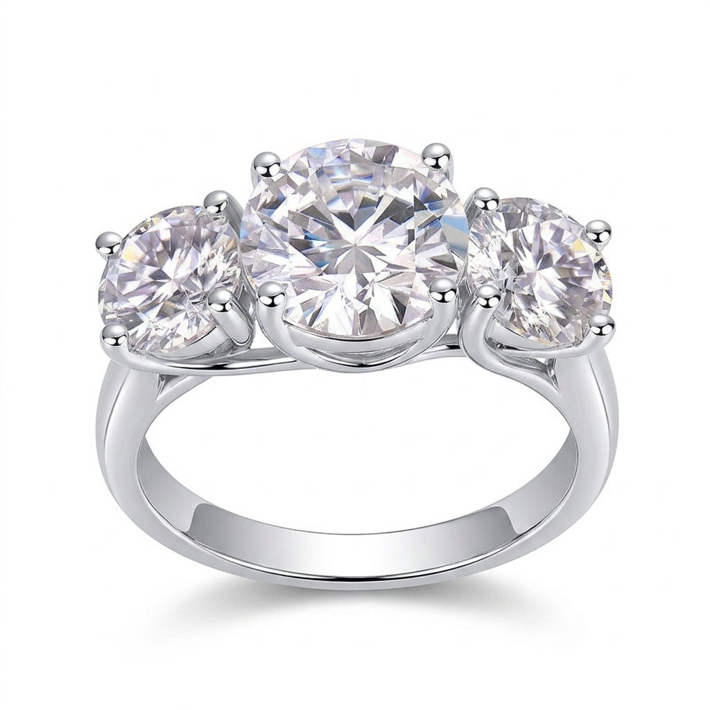 Classic round cut moissanite trilogy three stone engagement ring with plain band on white background.