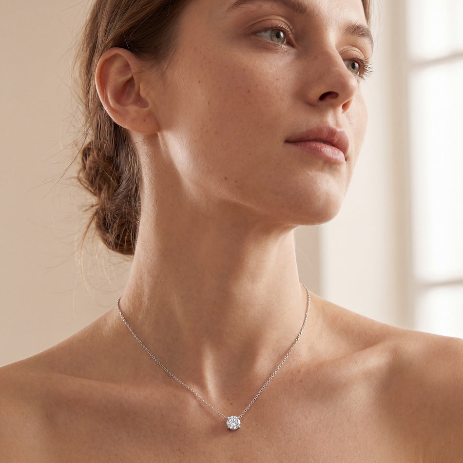 Model wearing classic four-prong round lab grown diamond solitaire necklace.