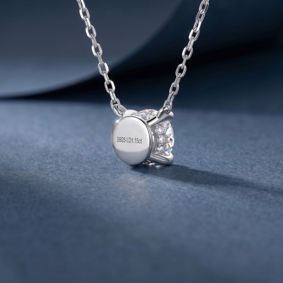 Back view showing polished flat solid cap and hallmark on round solitaire pendant.