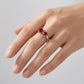 High-angle hand view of a model wearing a classic ruby bow-knot open ring on her index finger.