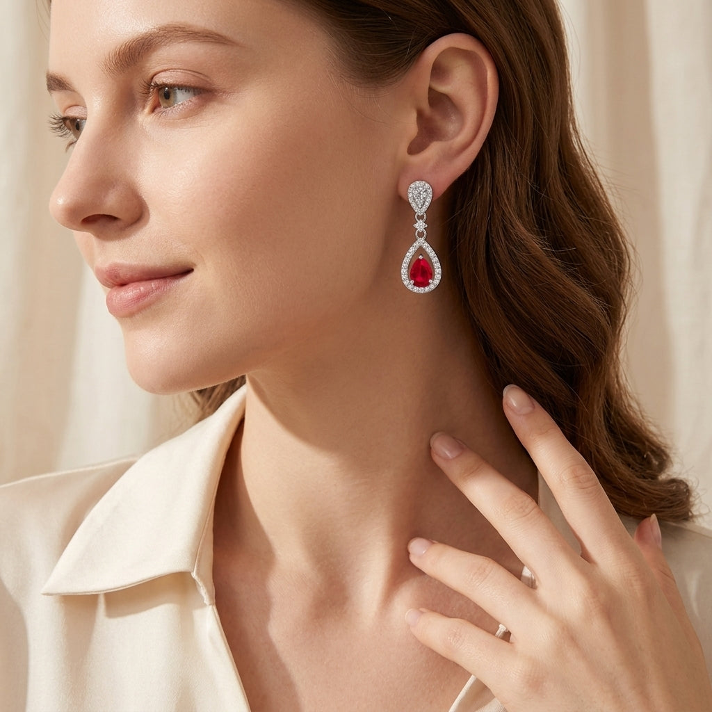 Side profile view of an elegant model wearing classic ruby pear-shaped chandelier drop earrings.