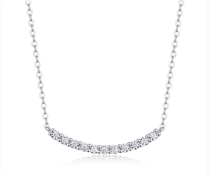 Classic shared prong moissanite curved smile bar necklace in 925 sterling silver.