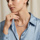 Model wearing classic shared prong moissanite curved smile bar necklace on collarbone.