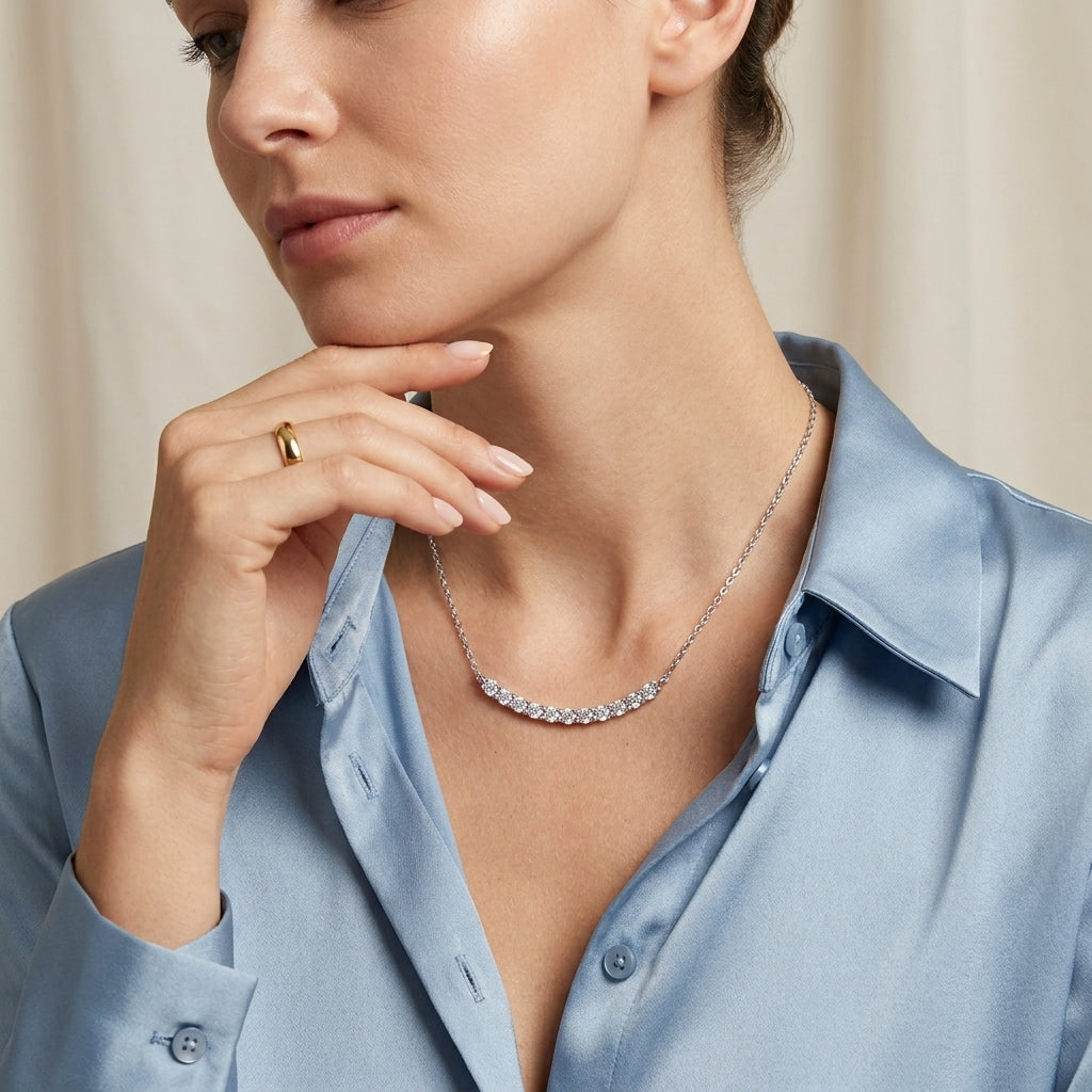 Model wearing classic shared prong moissanite curved smile bar necklace on collarbone.