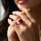 Close-up of an elegant model showcasing the large square-cut ruby statement ring under soft studio lighting.