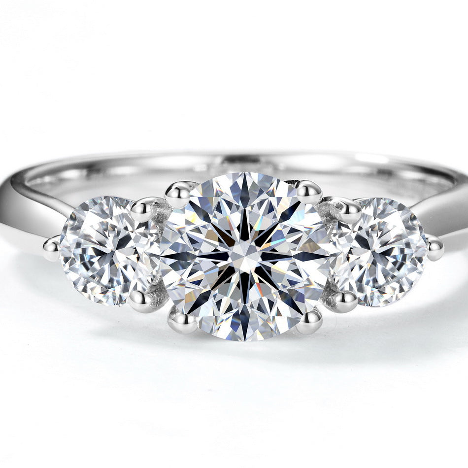 Extreme close-up shot of classic three-stone diamond accent past present future ring.
