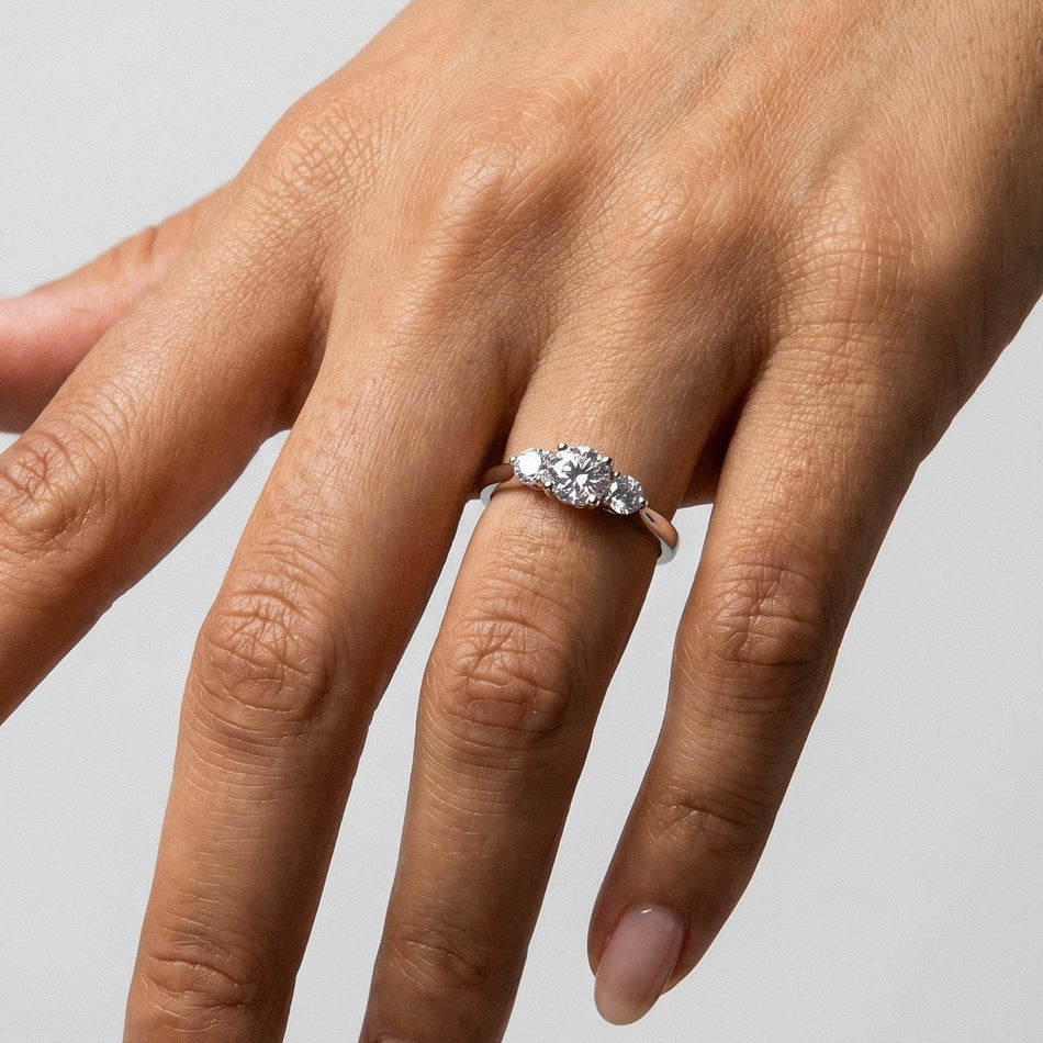 Alternative hand angle view of three-stone past present future diamond ring.