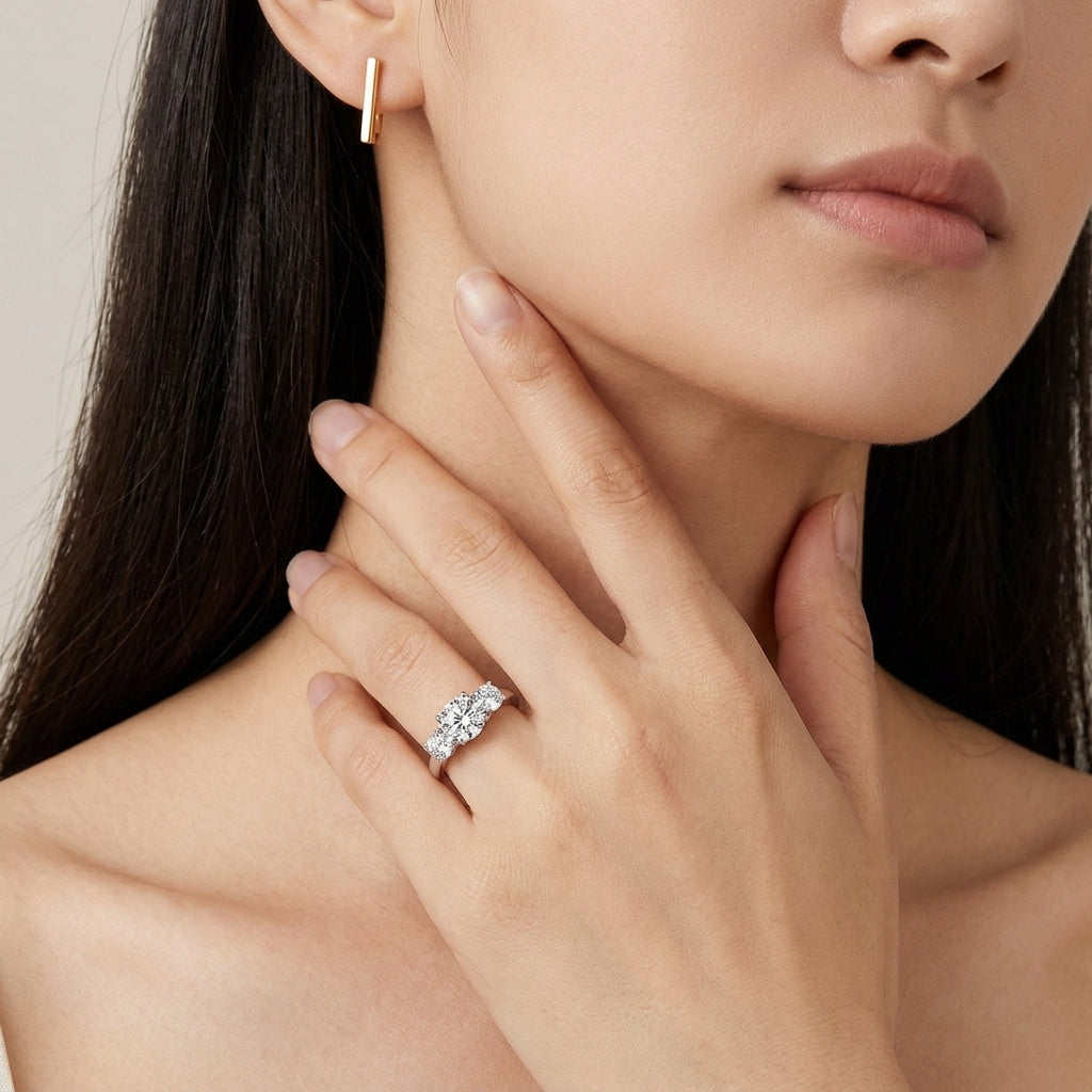 Model wearing classic three-stone diamond accent past present future ring.