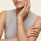 High-end fashion lookbook view of a model's wrist gracefully wearing classic Tory Burch double T layered pearl bracelet.