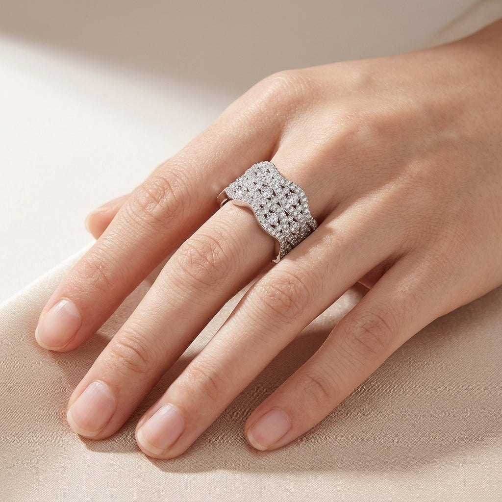 High-end fashion lookbook view of a model elegantly displaying a wide wave moissanite chunky pave crossover statement ring across her hand.