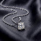 Cushion cut lab grown diamond solitaire pendant resting on dark silk fabric.