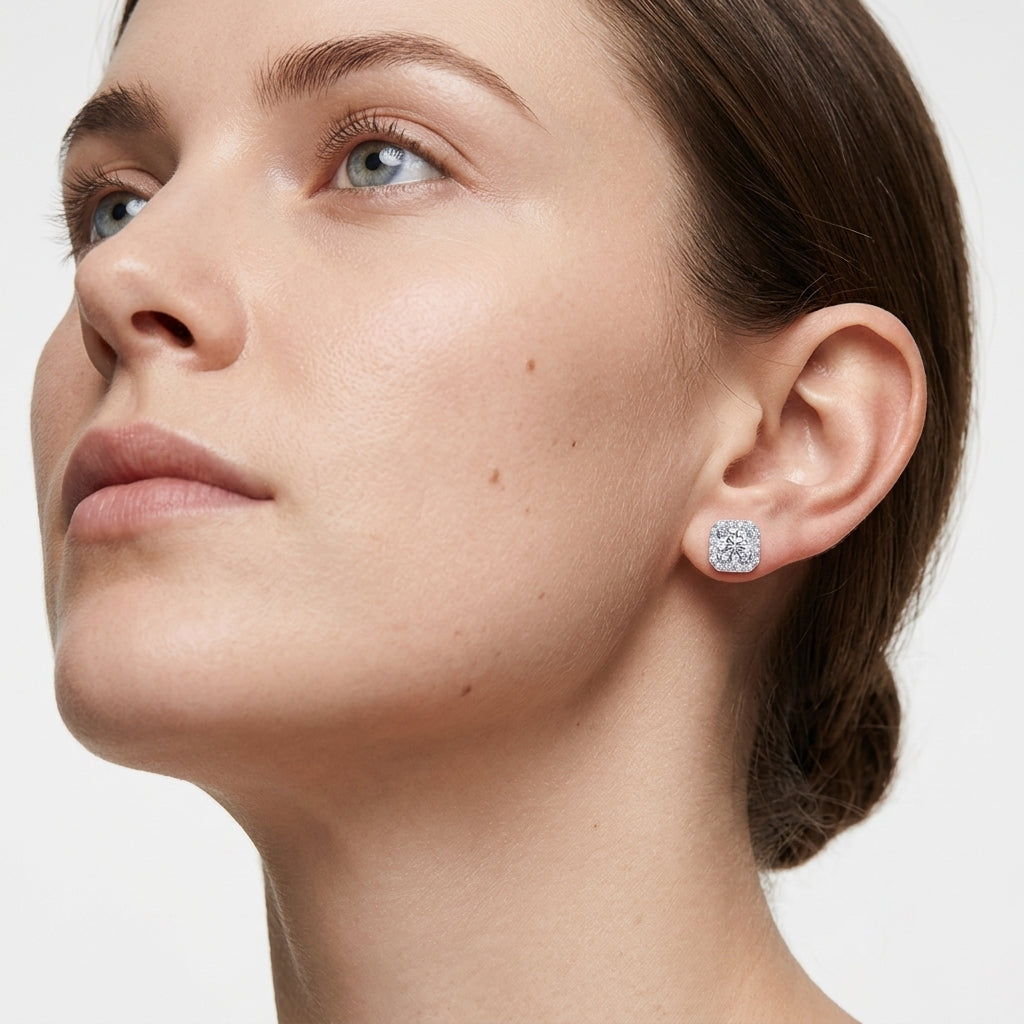Close-up side profile of model wearing cushion halo round diamond stud earrings.