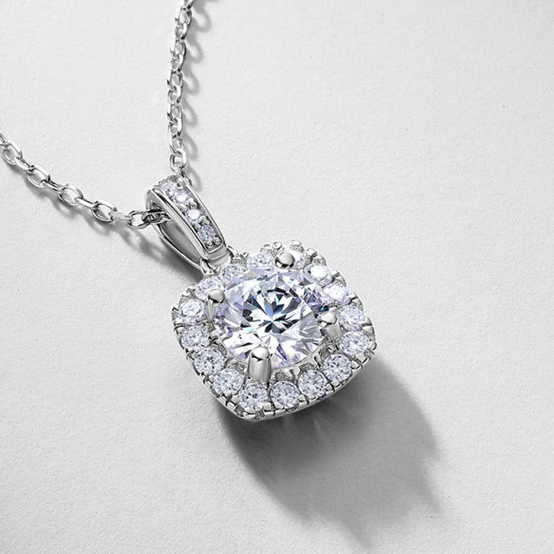 Close-up view of pave-set bail and cushion halo diamond setting on pendant.
